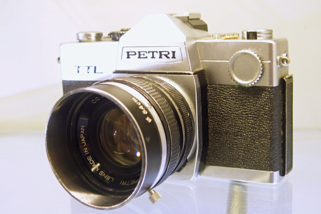 Petri TTL single lens reflex camera A silver and black Petri film camera viewed from the front.